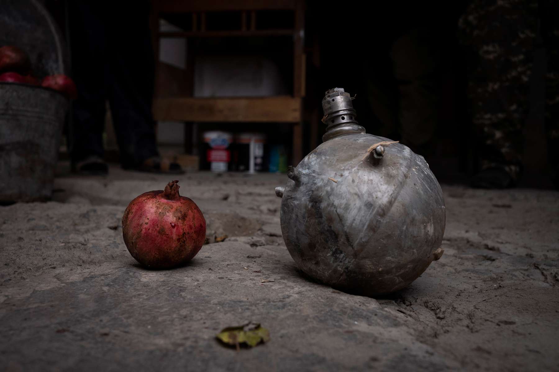 A family in Martakert returned home after the war to find this canister, which explosive ordnance disposal experts from the international landmine and explosives clearance organization the HALO Trust described as a pressure bottle from a guided missile or drone in their garden. A HALO staffer, noting its resemblance to one of the many pomegranates grown at this Martakert family's home, places them side by side to judge. 