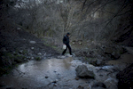 A young man walks to get water from a spring near Nor Kilikia village.   HALO has cleared land that allows for water pipes to be run into the village, but before that, all water needed to be collected from this river. 