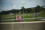 August 14, 2013 - HAVERHILL, IA: A young girl waves American flags as President Barack Obama's motorcade drives by her in Iowa. (Scout Tufankjian for Obama for America/Polaris)