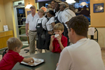 October 25, 2012 - Tampa, FL:  Two boys continue to eat their Krispy Kreme donuts as President Barack Obama poses with workers at the doughnut shop during a 48 hour straight swing of campaign events. (Scout Tufankjian for Obama for America/Polaris)