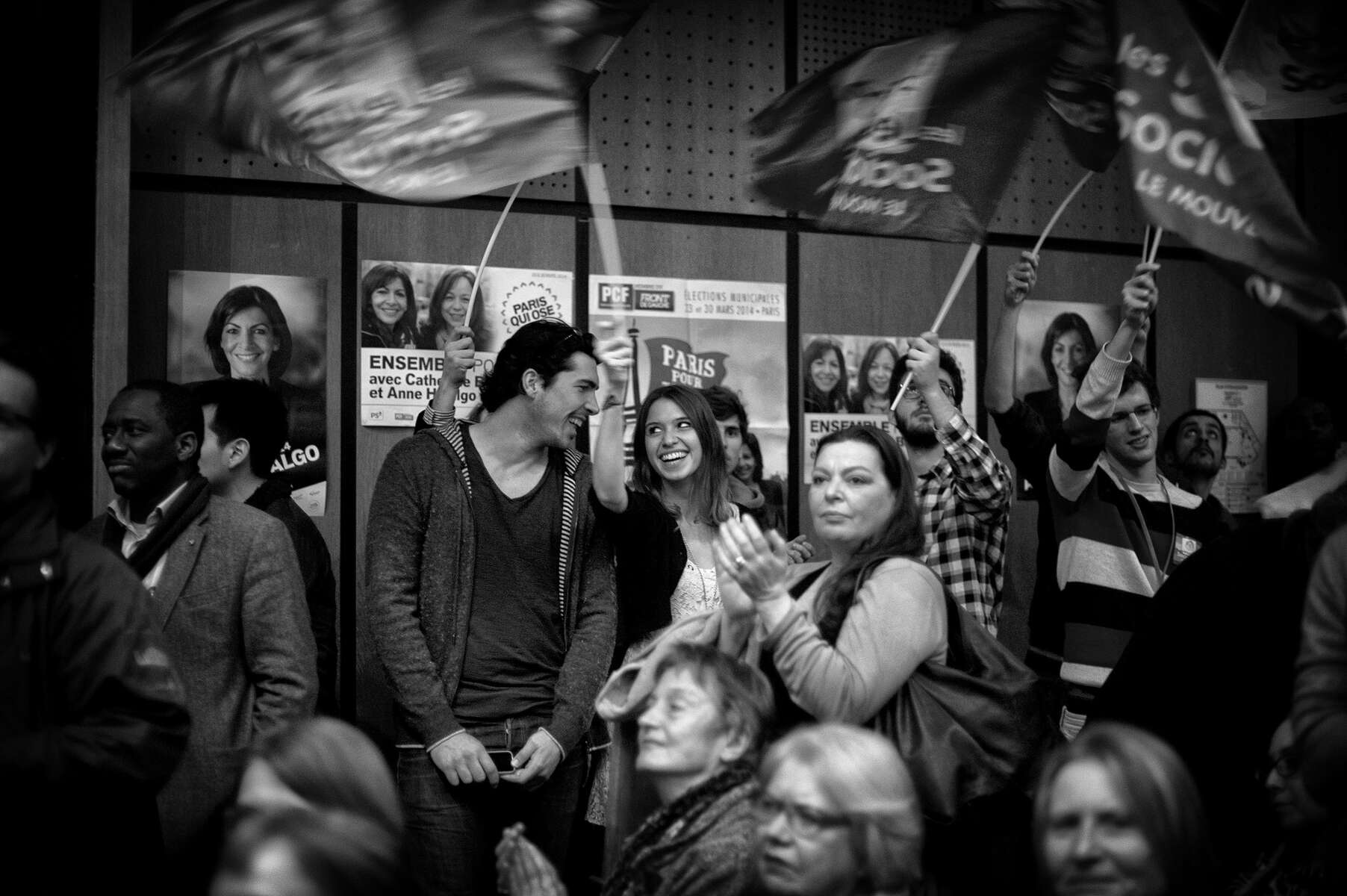 March 11, 2014.  PARIS, FRANCE- Supporters cheer and wave flags as mayoral candidate Anne Hidalgo speaks at a campaign event at Espace Reuilly in Paris' 12th Quarter.  For the first time in France's history, Paris will have a woman as a mayor - either Socialist Anne Hidalgo or Center-Right Nathalie Kosciusko-Morizet.  Photo by Scout Tufankjian