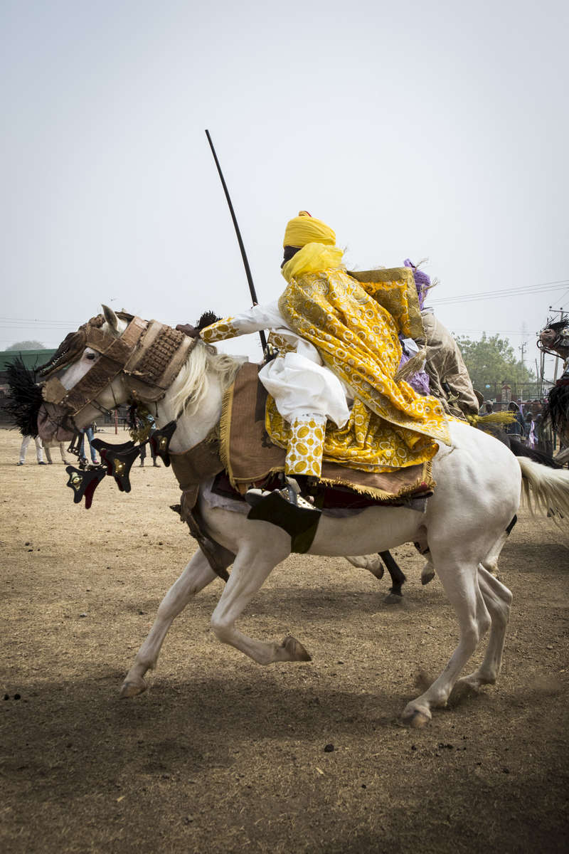 Mustafa Abba, younger brother to the Emir of Kano, Muhammed Sanusi II, races his horse outside the palace in Kano, Nigeria