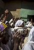 A girl holds up a young toddler joining other women as they raise their fists to the Emir of Kano, Muhammed Sanusi II, as he leaves the central mosque and returns to the palace in Kano, NigeriaThe raising of a fist refers back to a time when people used to raise a fist full of earth signifying that the land belongs to them.