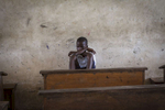 A student sits at the back of an empty classroom during recess at the R.S. Caufield Public School in Unification, Liberia 
