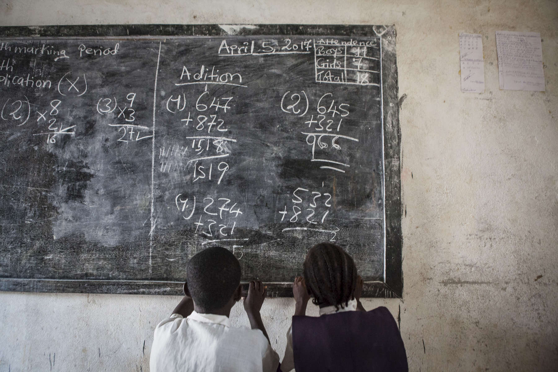 Students in Grade 2 work out math problems on the chalk board at the Kenlay Public School in Kenlay, Liberia