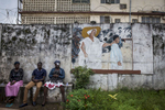 Patients sit on a bench at the entrance of the Kissy United Methodist Church Eye Hospital in Freetown, Sierra Leone