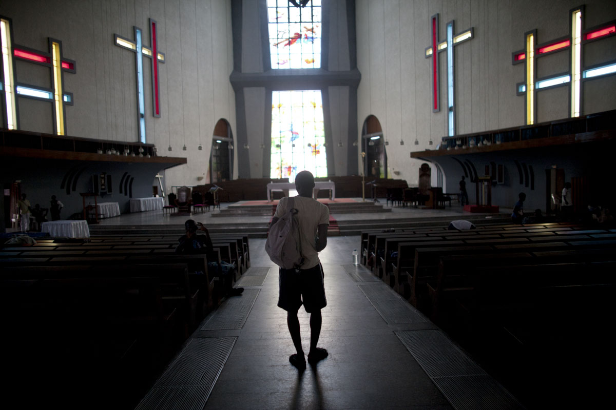 A man walks through the St. Paul's Cathedral where over 1600 displaced people have been residing for the last two weeks in Abidjan, Ivory Coast in April 2011. After months of post election violence and thousands of deaths, Laurent Gbagbo finally ceded power to Alassane Ouattara with the backing of French and UN forces allied with the FRCI.
