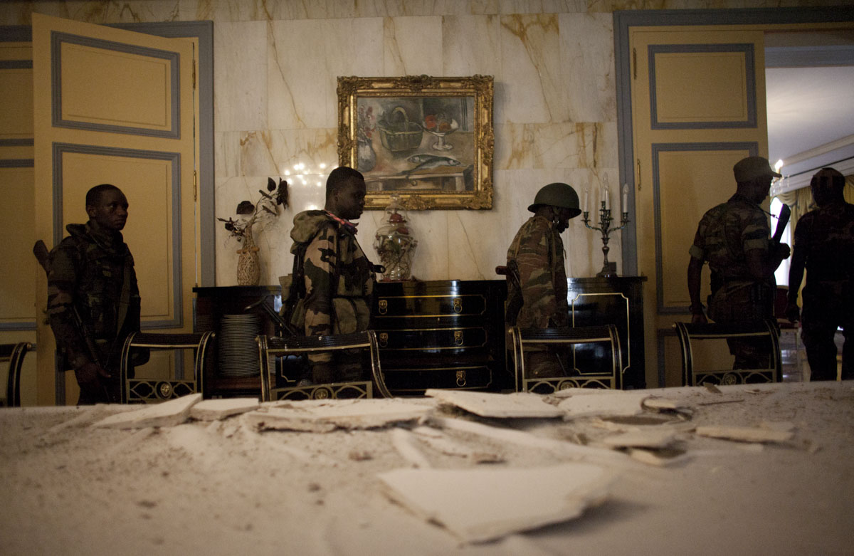 Republican Forces soldiers walk through the damaged presidential dining room at the Presidential Palace in Abidjan, Ivory Coast in April 2011. Days after Laurent Gbagbo ceded power after heavy attacks by the French and Republican Forces, control has been established of the palace after looting took place.  .(Jane Hahn)