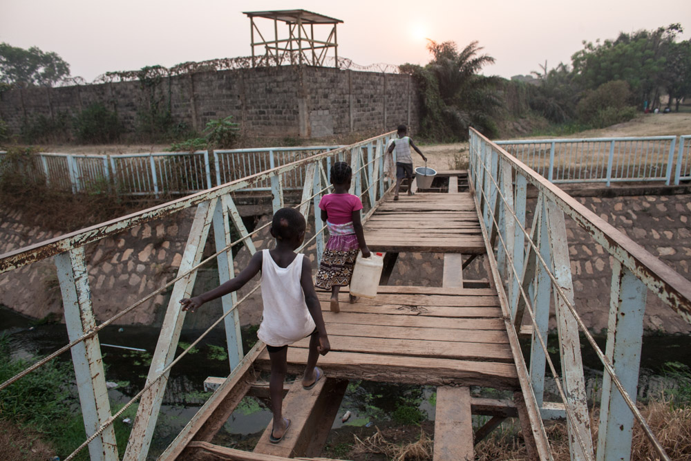 Children cross a dilapidated bridge outside the Moroccan UN Peacekeeper base between the Castors neighborhood and PK5 in Bangui, Central African Republic.