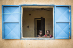 Luma, 6 (l) and Busam, 9, stand in the window of their room at an internment camp for ex-Boko Haram combatants and their families in Goudoumaria, Niger, August 2018. 