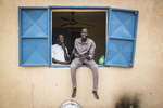 Mustafa, 20 (c) and Usman, 17, stand in the window of a dormitory room  at an internment camp for ex-Boko Haram combatants in Goudoumaria, Niger in August 2018. 