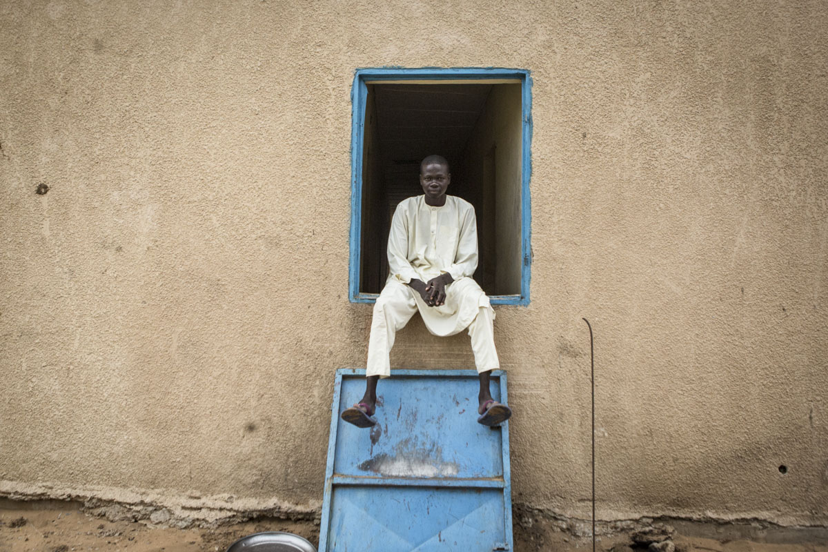 Ibrahim, 22, sits in a window at an internment camp for ex-Boko Haram combatants in Goudoumaria, Niger, August 2018. 