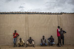Men lean against a wall at an internment camp for ex-Boko Haram combatants in Goudoumaria, Niger, August 2018. 