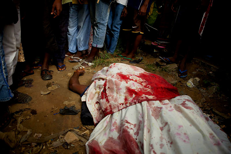 A crowd gathers around the body of a man killed during continued fighting between President Alassane Ouattara supporters and security forces loyal to former President Laurent Gbagbo. Forces raided the pro-Ouattara neighborhood in the early morning hours leaving at least four dead. 