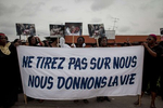 Women march through the streets mourning the deaths of the victims of the political violence, carrying a sign translating to {quote}Do not shoot us. We give life{quote} the morning of Tuesday, March 8, 2011 in Treichville, a suburb of Abidjan, Ivory Coast. This afternoon in Treichville, after finishing prayers (both Christian and Muslim) the marching women encountered the {quote}Compagnies Republicaines de SecuritÈ{quote} (CRS), special riot police loyal to Laurent Gbagbo. Its reported that the neighborhood youth guard stood in a line between the women and the CRS to protect the women when the CRS opened fire. At least four were killed including one woman and unknown number were injured.