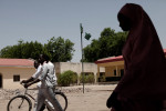 Students pass a tattered Nigerian flag at the Sanda Kyarimi Government Day Secondary School in Maiduguri, Nigeria in May 2013. After the Sanda Kyarimi School was attacked by Boko Haram in late March, many students and teachers have yet to return out of fear of another attack.