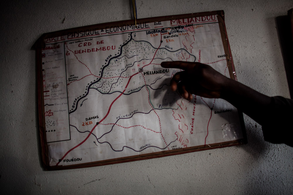 Cécé Kpoghomore, 45, director of the school, points to a map made by a student in his office in Meliandou, Guinea on January 25. 2015. 