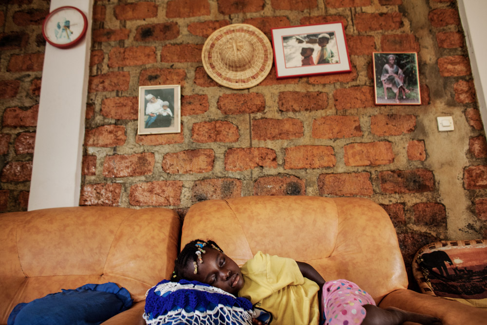 Reverend Moises Mamy's granddaughter sleeps in their home in N'zao, Guinea on January 23, 2015. Reverend Moises Mamy was one of eight people killed on September 16, 2014 while visiting the town of Womey in an attempt to educate people about Ebola.