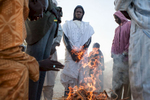 Men warm themselves by the fire in Djalori Camp in Diffa, Niger.300,000 people displaced by the Boko Haram crisis are taking refuge in southern Niger, straining the already vulnerable environment of the Lake Chad Basin. 