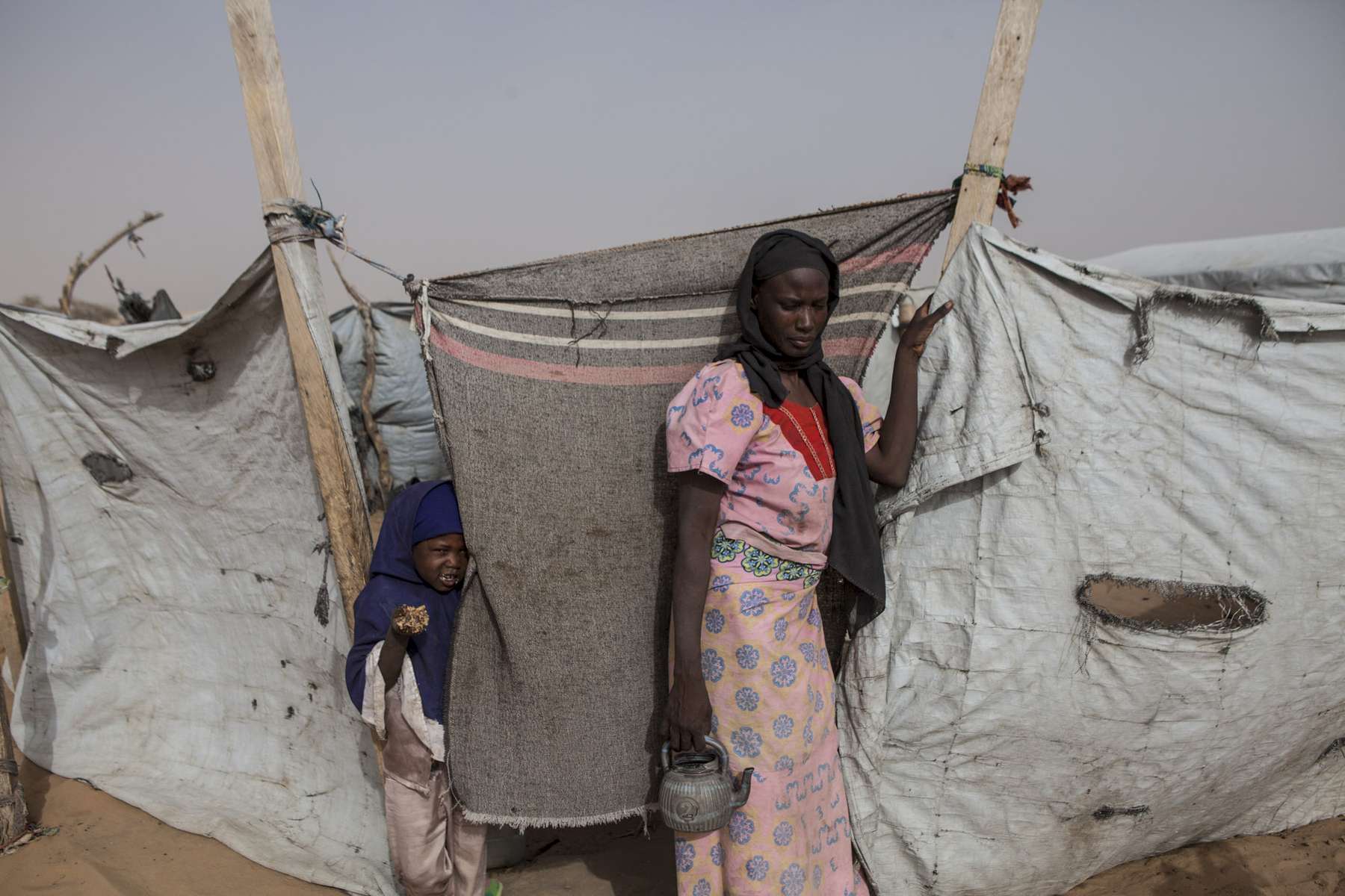 Fati Moussa, 27, stands outside her shelter at the Dar es Salaam refugee camp in Baga Sola, Chad February 2017. Moussa originally from Baga, Nigeria, fled across the lake to Baga Sola after surviving one of Boko Haram's worst massacres in January 2015. Unable to farm she  and her family survives on the charity of other refugees and the limited aid provided by under-funded aid agencies. The Boko Haram crisis was originally contained within northeastern Nigeria, where the extremist group focused their terror, but in 2015, as the regions multinational force began to close in on its areas of control, Boko Haram crossed borders and started to target neighboring countries. The spread of the crisis from NE Nigeria to its neighboring countries surrounding the Lake is resulting in one of the largest humanitarian crisis in the world. 