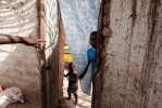 Fissa, 33, directs his younger brother standing in the doorway of his home in Perai Village