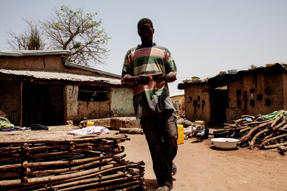 Susso, 38, walks through his compound in Dampha Kunda Village