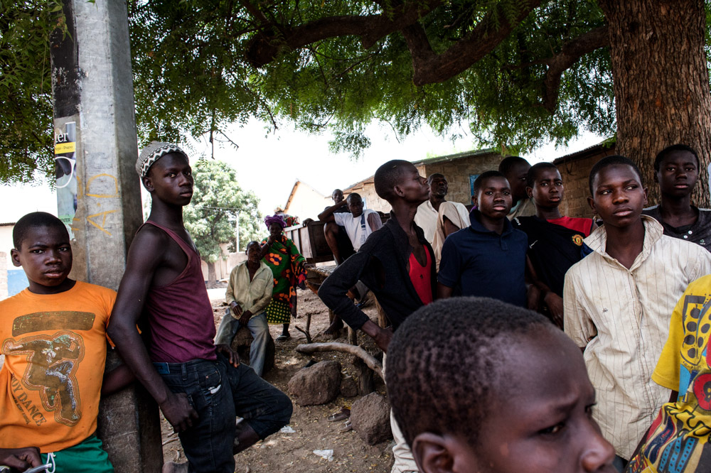 Unemployed young men gather under a tree in Dampha Kunda Village. The lack of employment across the country is a major contributing factor in the decision to take {quote}The Back Way{quote}