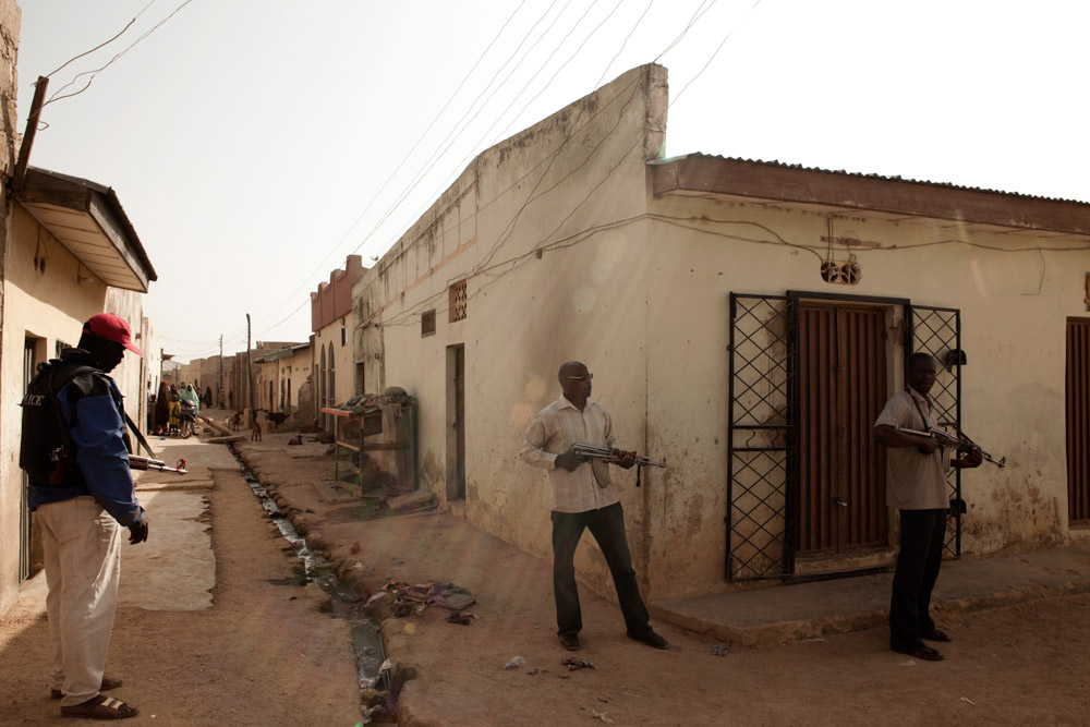 Nigerian security forces patrol the streets of the Tsamiyar Boka neighborhood the morning after an overnight raid which killed suspected Boko Haram member Uzairu Abba Abdullahi and his wife in their home in Kano, Nigeria. 2012