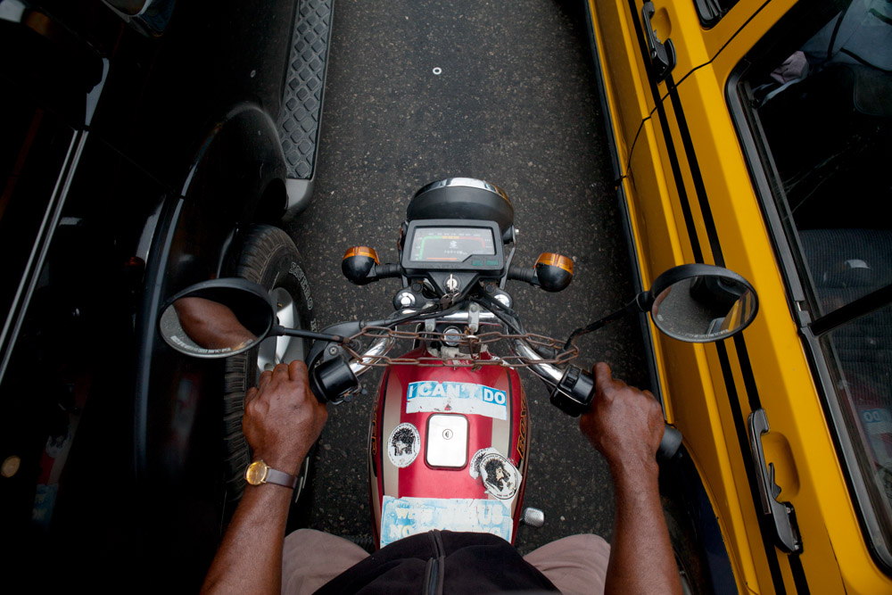 a motorbike taxi rides between lanes in lagos, nigeria
