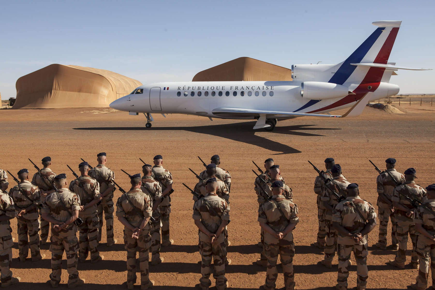 French troops part of Operation Barkhane stand at attention as French President Francois Hollande's private jet lands in Gao, Mali on Friday, January 13, 2017.