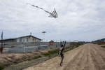 A boy flies a kite made from plastic bags in the Protection of Civilians (POC) site at the United Nations Mission in South Sudan (UNMISS) base in Malakal, South Sudan on Thursday, July 7, 2016. The POC site houses close to 32,000 displaced people mainly from the Shilluk and Nuer tribes in the Upper Nile State. In February of this year, violence broke out inside the camp as many armed members of the Dinka tribe, who resided in the camp at the time, along with members of the SPLA who infiltrated the camp, attacked the Shilluk and Nuer in the camp destroying large sections of the site resulting in many wounded and dead. The UN came under scrutiny due to the slow response of the peacekeepers to protect the civilians during the two day ordeal. During the violence, thousands demanded entrance into the UNMISS base at Charlie gate, seeking safety, but the opening of the gate was delayed for protection of the UN. 
