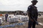 A member of the United Nations Police, UNPOL, stands guard during a World Food Program food distribution in the Protection of Civilians (POC) site at the United Nations Mission in South Sudan (UNMISS) compound in Malakal, South Sudan on Friday, July 15, 2016. The Malakal POC site houses over 32,000 displaced people mainly from the Shilluk and Nuer tribes. In February of this year, members of the Dinka tribe, who resided in the camp at the time, carried out a coordinated attack within the site leading to the destruction of hundreds of shelters and many deaths. Since then, most members of the Dinka tribe have fled to Malakal town where they occupy the homes of those still displaced. The UN has assured the displaced people that increased security measures around the camp will protect them from any further attack. Most of the displace are not convinced. 