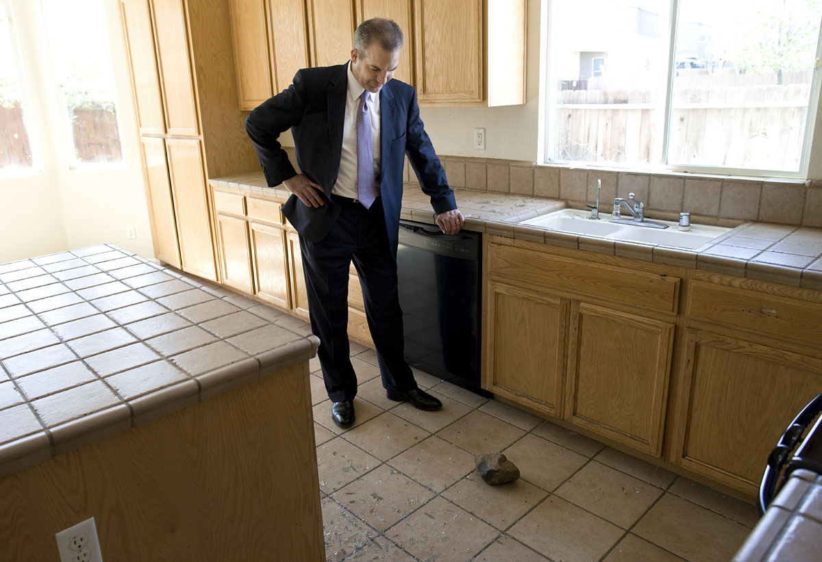 Real estate agent Mike Blower inspects damage in an abandoned forclosed property in Stockton, CA.
