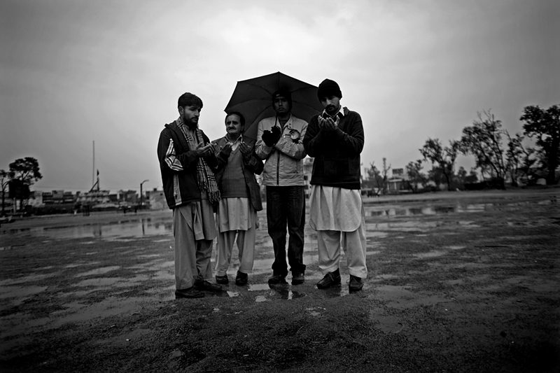 A small group of men pray in a park in Rawalpindi, Pakistan.