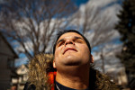 Hector raises his face toward the afternoon sun while waiting for his mobility instructor on a cold winter day in Bridgeport, Conn. Hector works with his trainer on strengthening his ability to travel independently using a cane and his other senses.