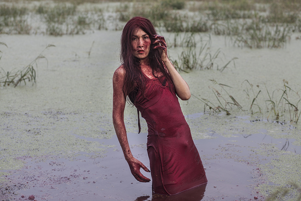 Beijing, July 30 : performance artist Han Bing stands in a polluted lake during an art project   on the outskirts of Beijing.