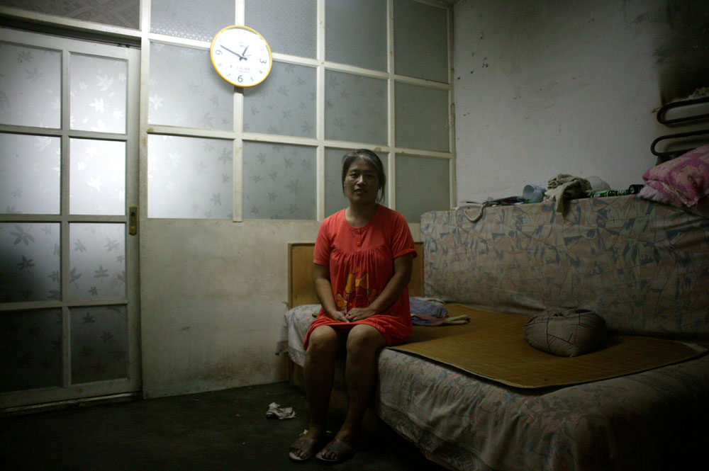 August 2007 : a woman sits in her tiny one bedroom before it is demolished....