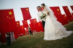 A newly wed couple poses for a souvenir picture in a park on October 1, 2006, Beijing. 
