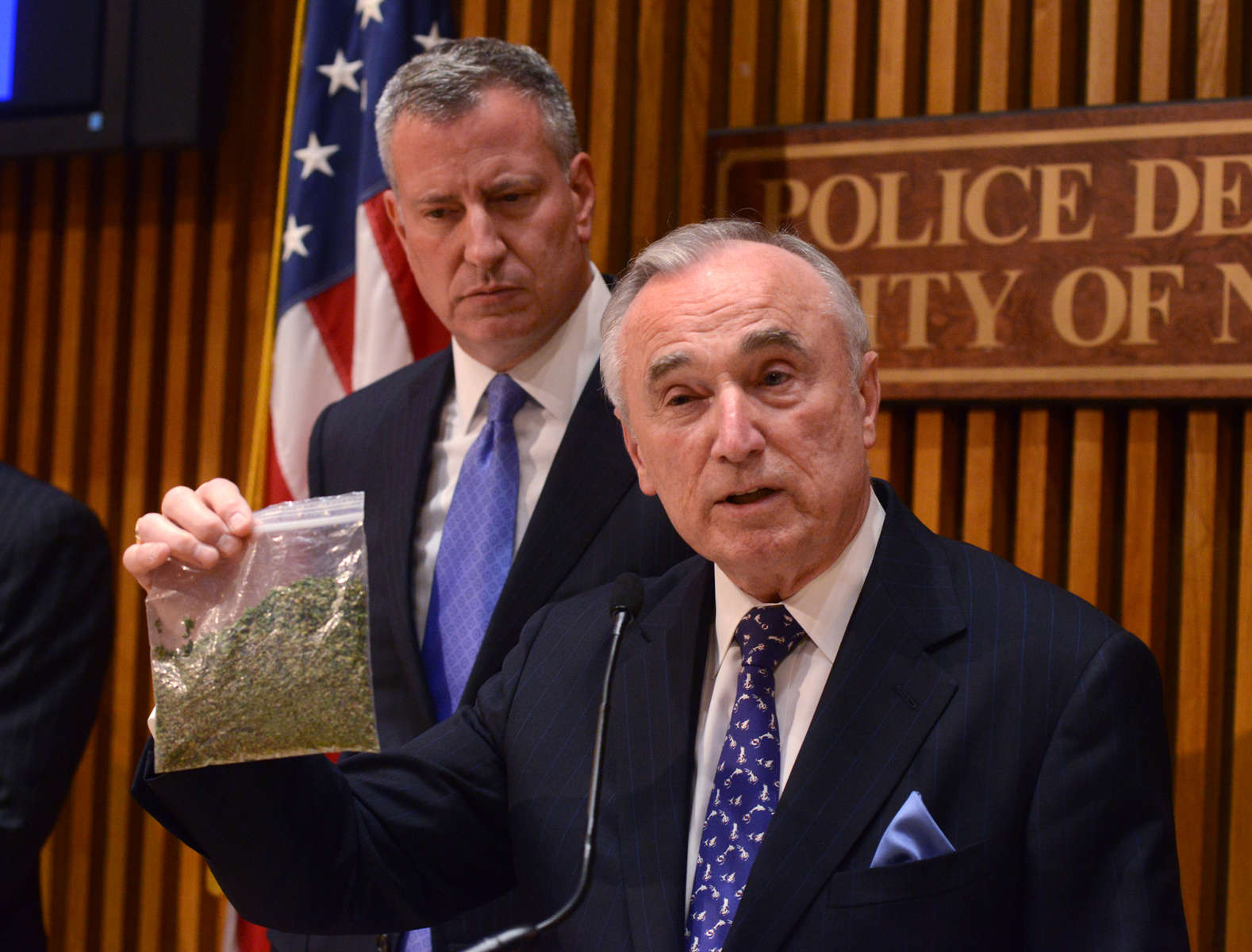 NYC Police Commissioner William Bratten, right holds a bag of oregano simulating 25 grams of marijuana during a press conference announcing news guidelines regarding small amounts of marijuana possesion. Mayor Bill deBlasio is at left One Police Plaza  Monday November 10, 2014