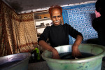 A worker dips cotton cloth into basin containing fixer at the last stage of coloring process in the Jaipur cooperative for cotton and carpet production. The colors used are natural and paintings of fabrics are done manually. 