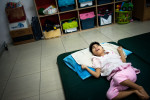 Nang lays on the mattress in the dormitory of the Camilian home. 