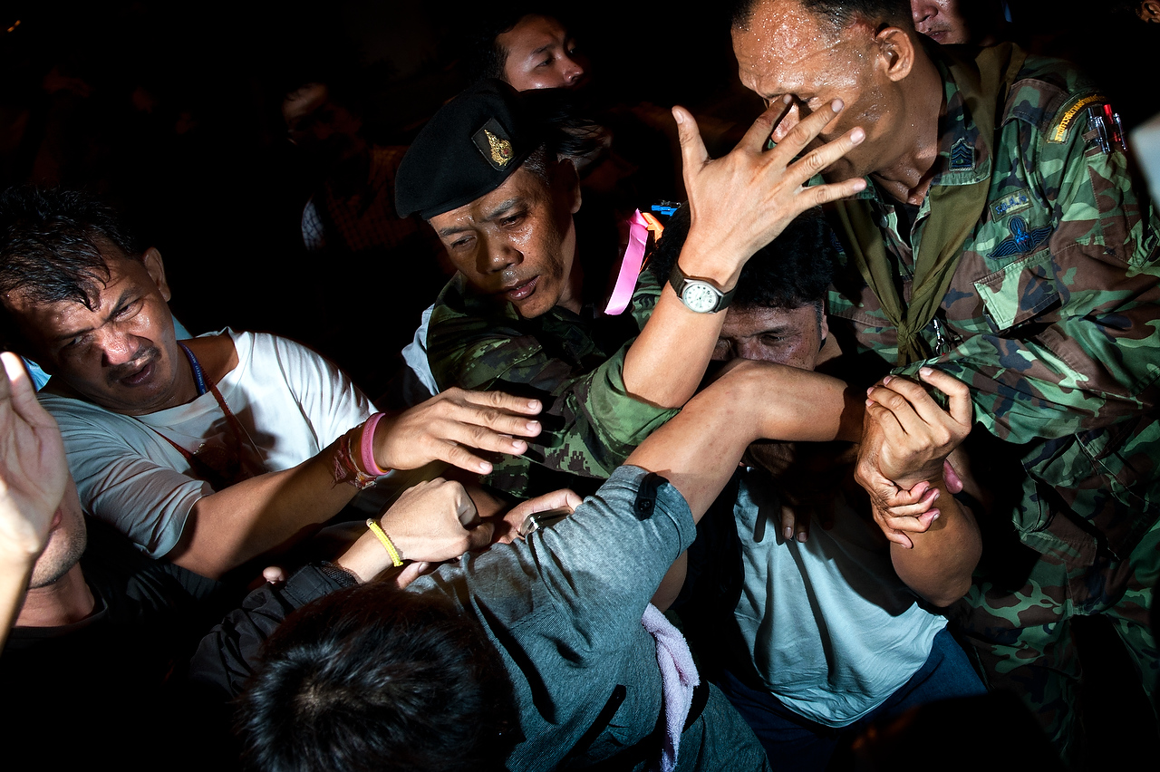 Thai soldiers protect a man allegedly suspected to be involved in explosions from angry crowd of pro-government group on April 22, 2010 in Bangkok, Thailand.