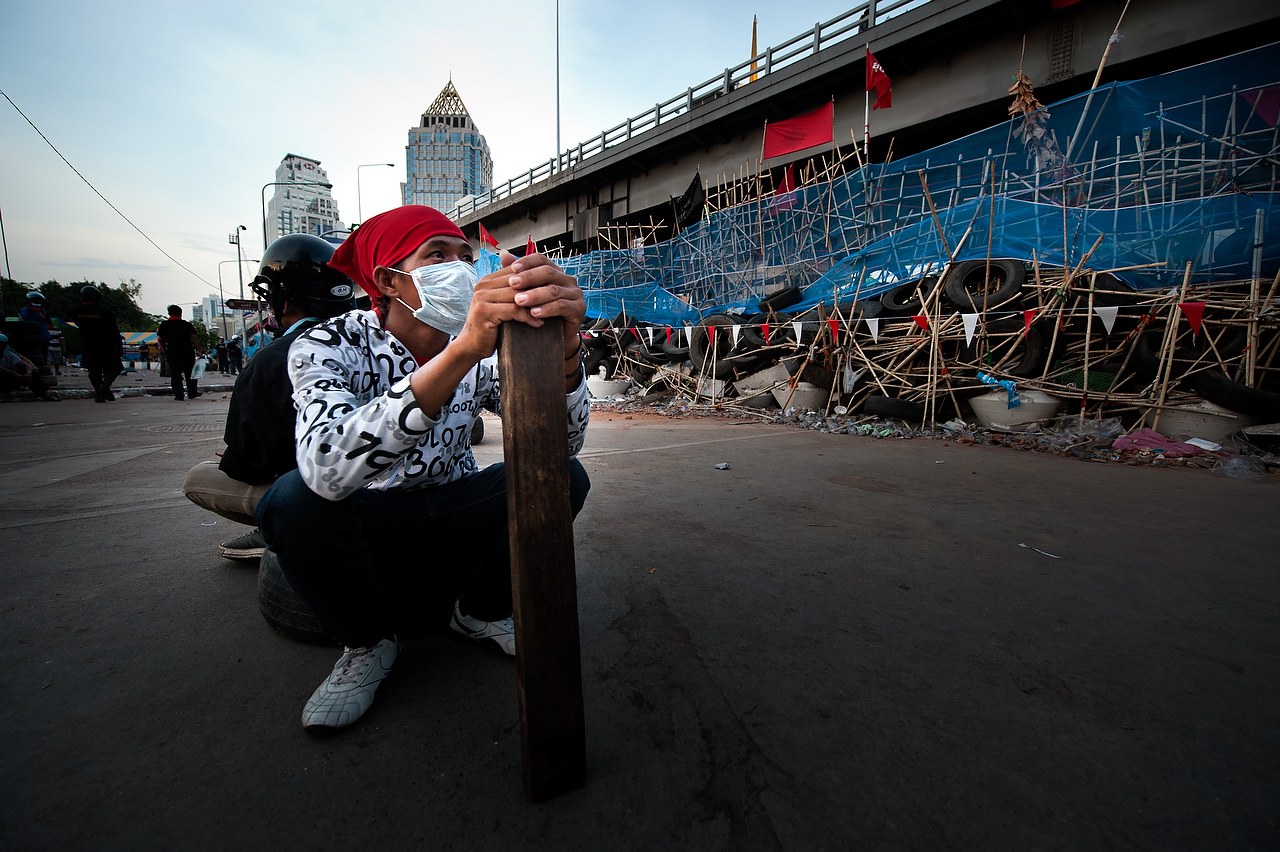 An anti government protester holds a piece of wood  inside fortified red shirt area in Silom, Bangkok's financial district as the anti government protesters are seen gearing up to brace for possible army crack down on 26 April 2010 Bangkok ThailandThai political crisis have been plunged into further uncertainty as the Prime Minister Vejjajiva rejected UDD's proposal to disolve the parliament and call for the ballot elections within 90 days. Prime ministers statement left red shirts to brace for the imminent crack down by the Army and the police.