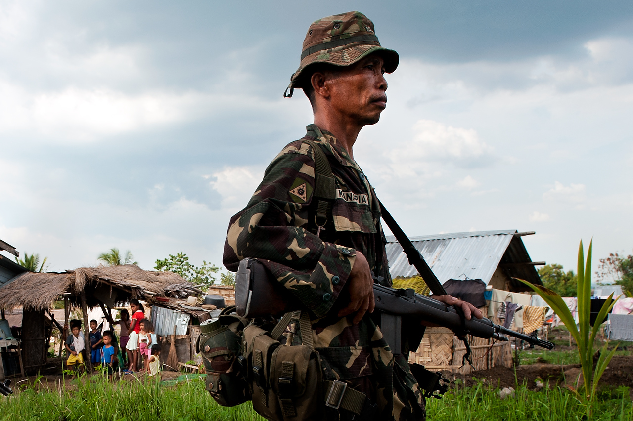 Member of the CAFGU paramilitary unit passes by village of Dattu Hoffer in Maguindanao.CAFGU is irregular auxilary force of the Armed Forces of Philippines (AFP). It was created in 1987 when the Filippino government provided them with weapons to prevent the re-infiltration of insurgents into communities that have already been cleared. By 2007 there were estimated to be some 60,000 CAFGU members active. Number still remains high despite allegations of human rights abuses commited by CAFGU.  
