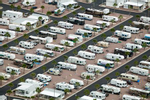 Rows of RVs at the Palm Creek Golf & RV Resort. Irrigated golf courses and palm trees create the illusion of paradise at the retirement community and RV park. While using desert land is inexpensive in the short term, it is costly in the long term because of the energy and resources required to maintain the façade.