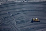 Shoveling piles of tar sands refining byproduct Petroleum Coke