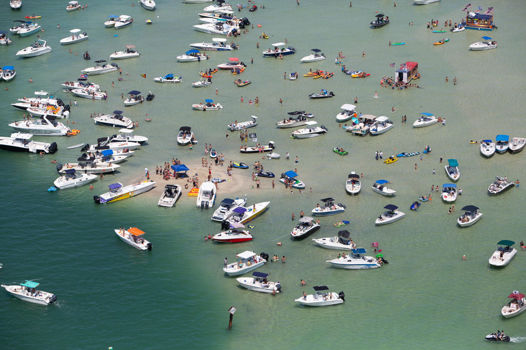 A school of speed boats and jet skis crowd to Haulover Sandbar, a popular offshore destination north of Miami, Florida.