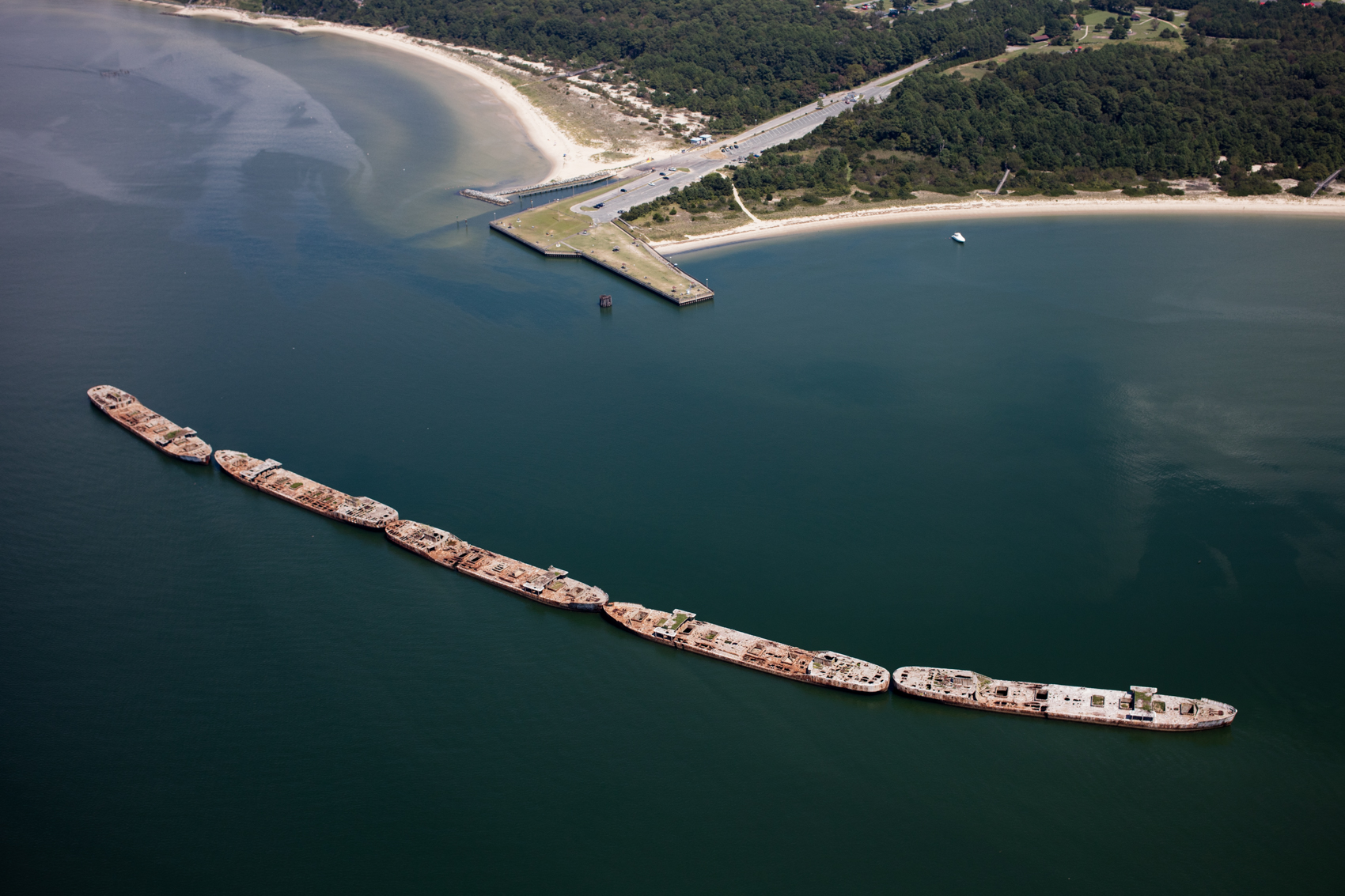 Concrete ships built during World War II steel shortages were sunk in 1948 to provide a breakwater for the Cape Charles, Virginia ferry port. The ferry no longer runs, but the ships continue to shelter the pier and shoreline.