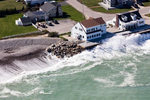 Waves crash against the end of a seawall in Scituate, Massachusetts, a town which has faced the brunt of many historic storms. Parts of the seawall are 80 years old and in dire need of repair.