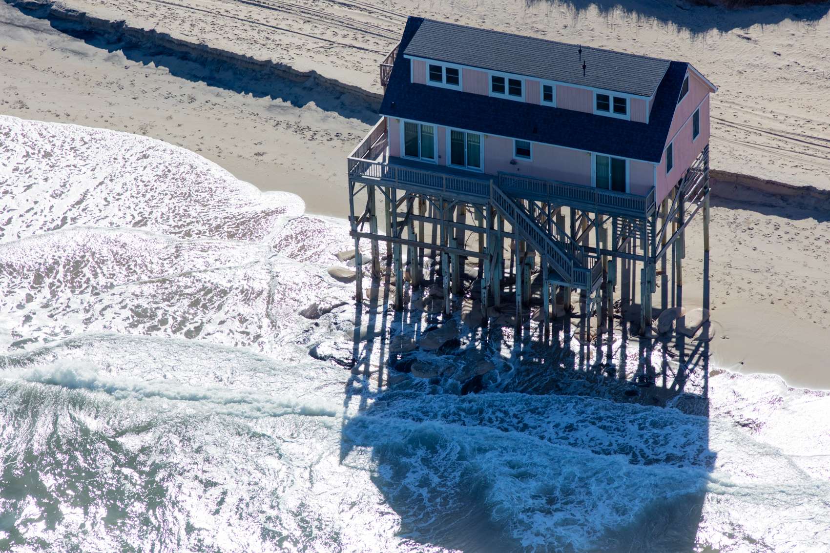 Houses in Nags Head, North Carolina raised on stilts to protect against flooding. Property owners have watched their beaches slip away, and residences that once stood on stable ground are now randomly scattered in the surf zone due to erosion.